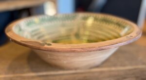 Unieke handgemaakte aardewerk schaal met karakteristiek groen decor.