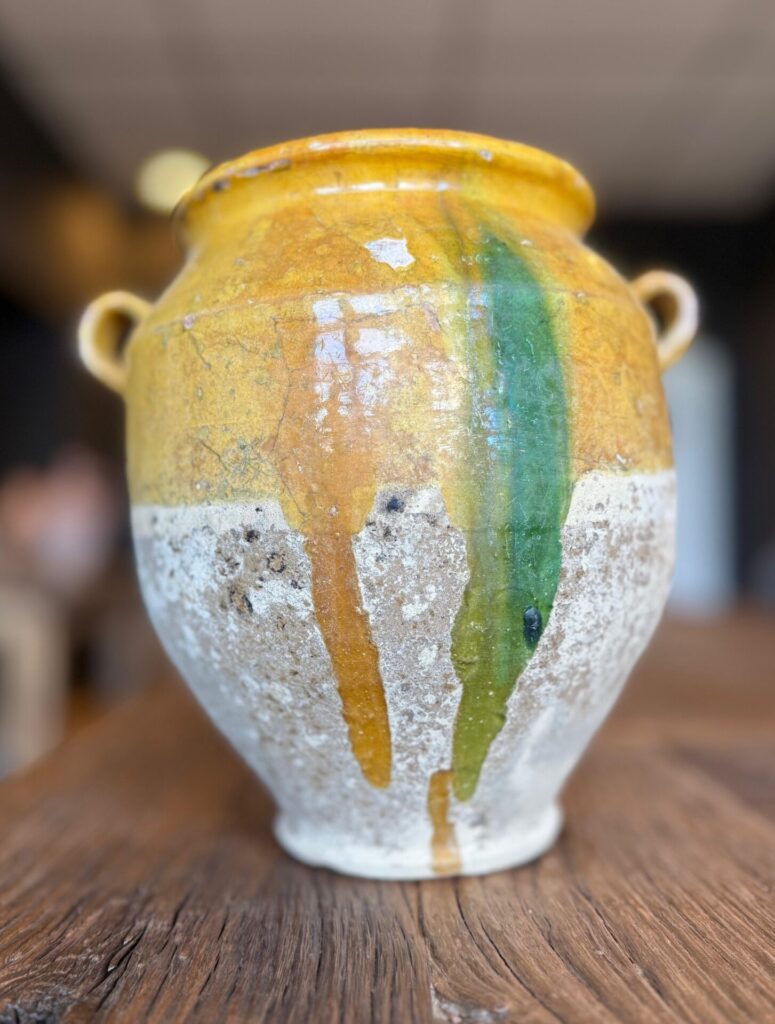 Unieke aardewerk kruik met warme gele tinten en karakteristieke groene glazuurstrepen.